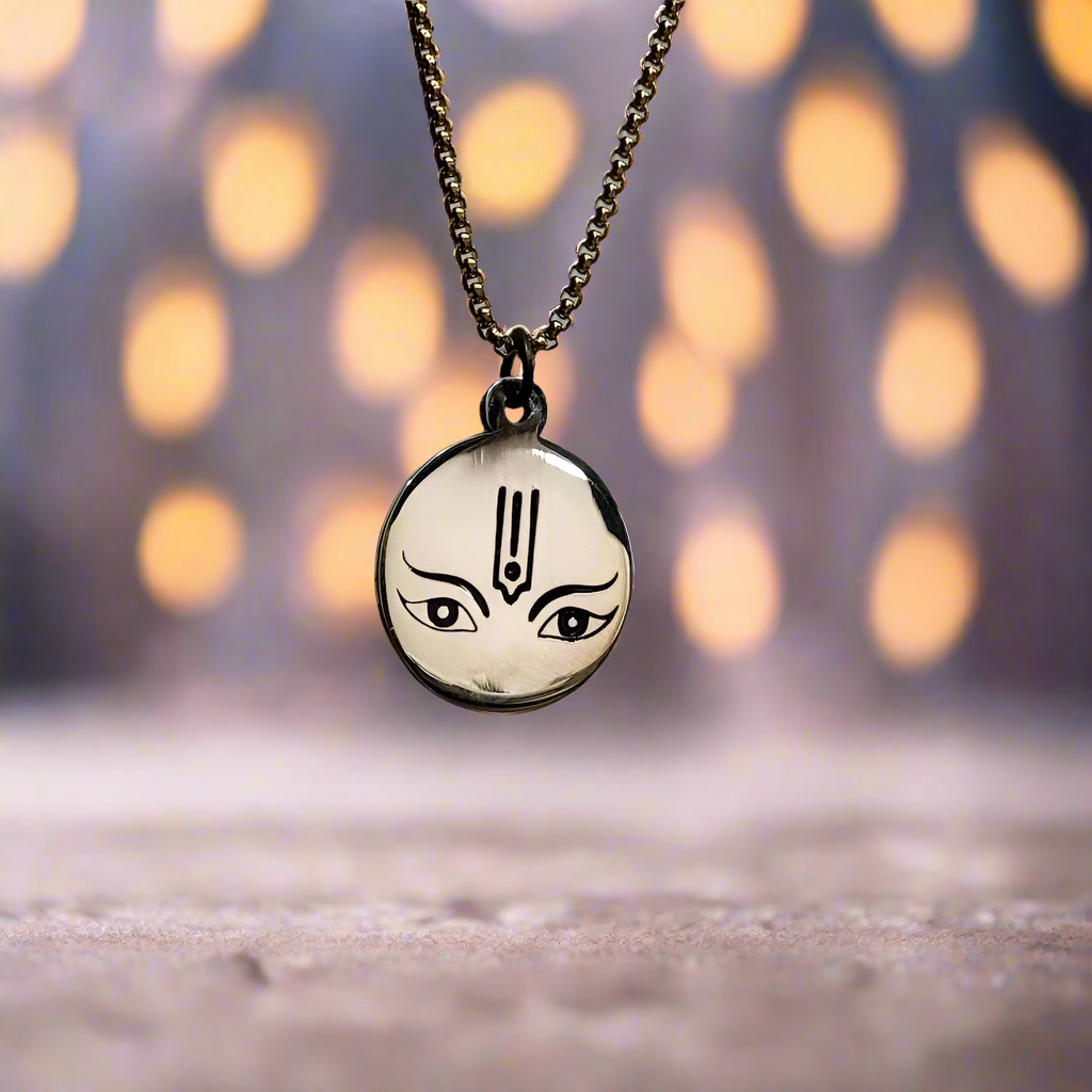 Necklace with a pendant featuring an artistic face design on a neutral background