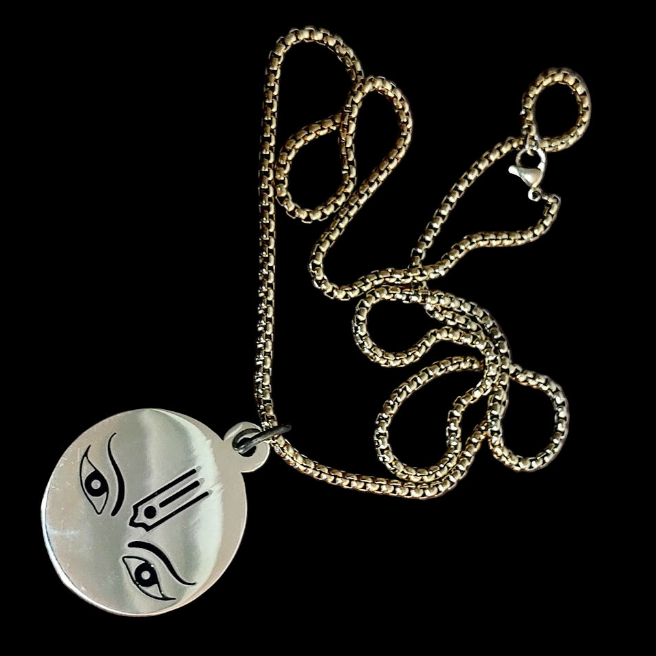 Necklace with a round silver pendant on a wooden surface