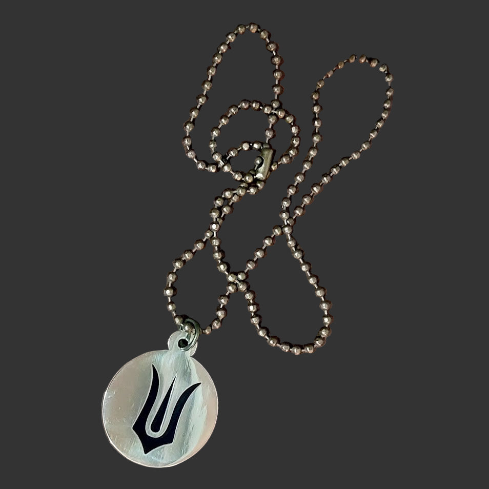 Necklace with a pendant featuring a symbol on a wooden surface