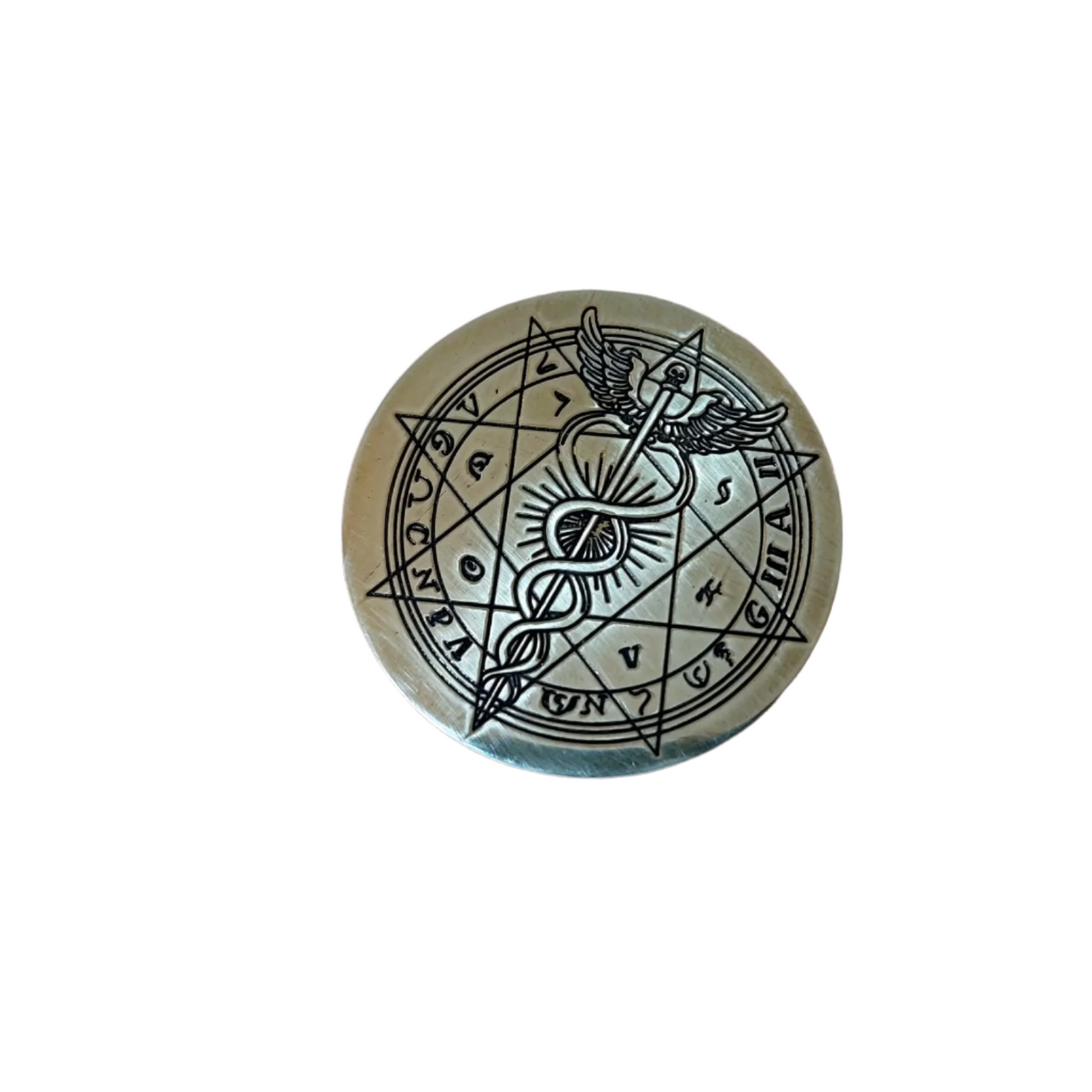 Bronze coin with intricate design held in a hand, keyboard in the background