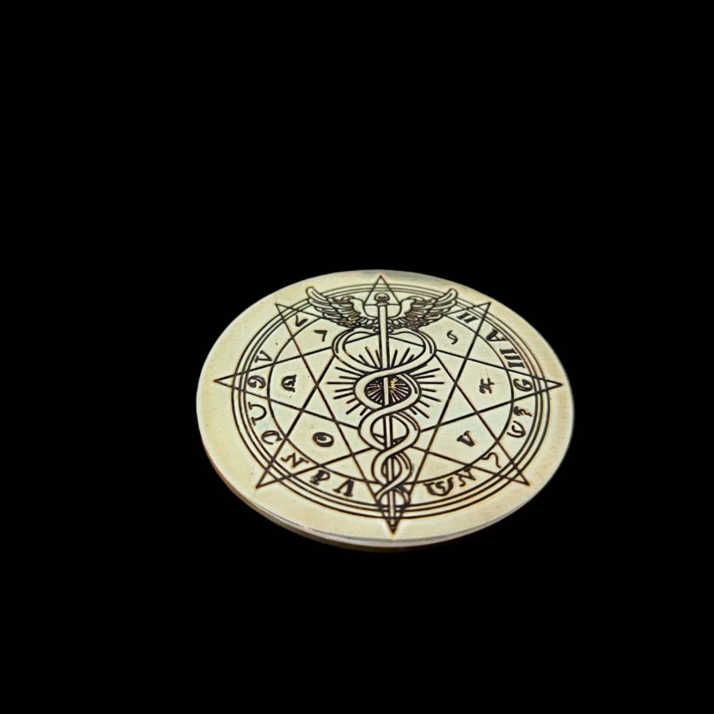 Decorative coin with intricate design on a dark surface