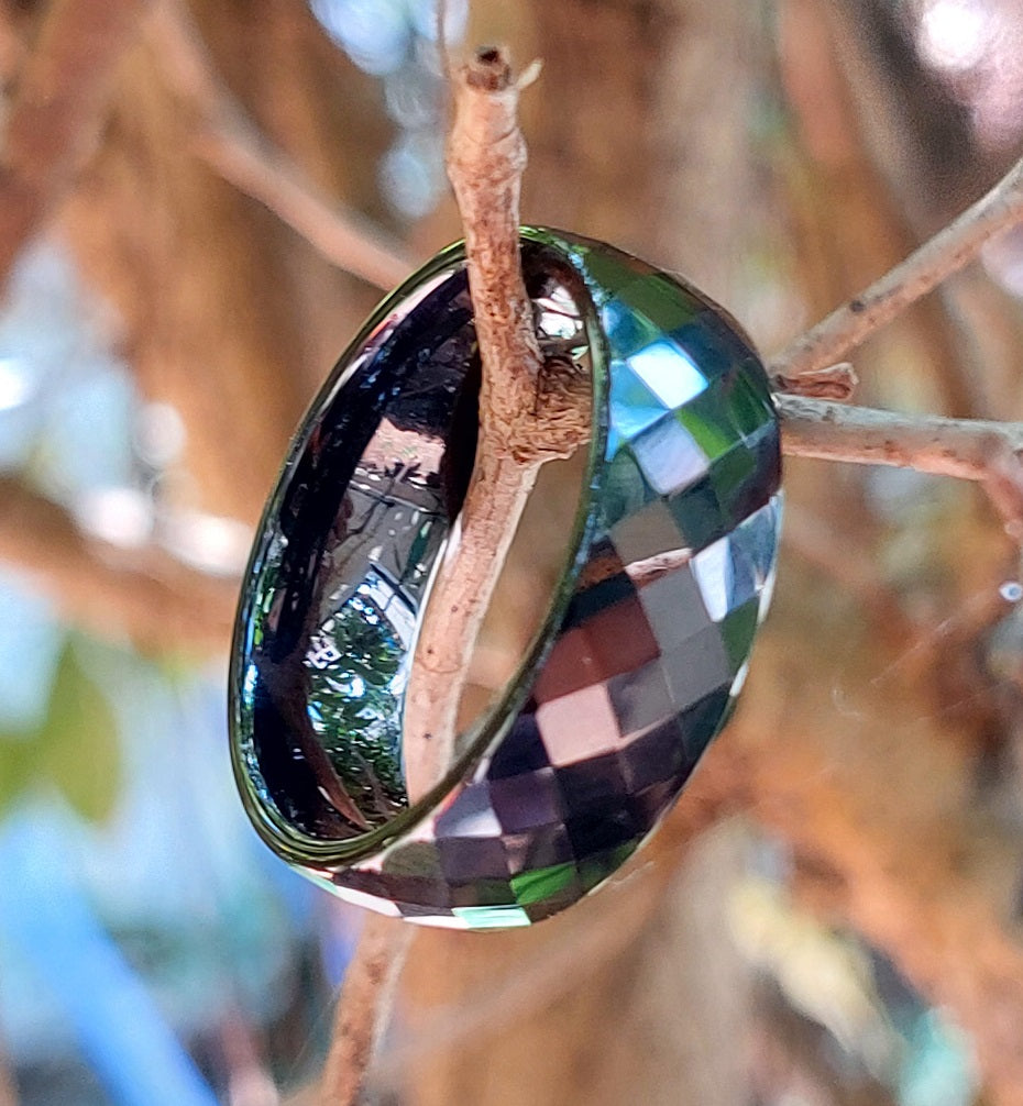 Classic Wide black ceramic ring hanging on a twig, outdoor lifestyle shot