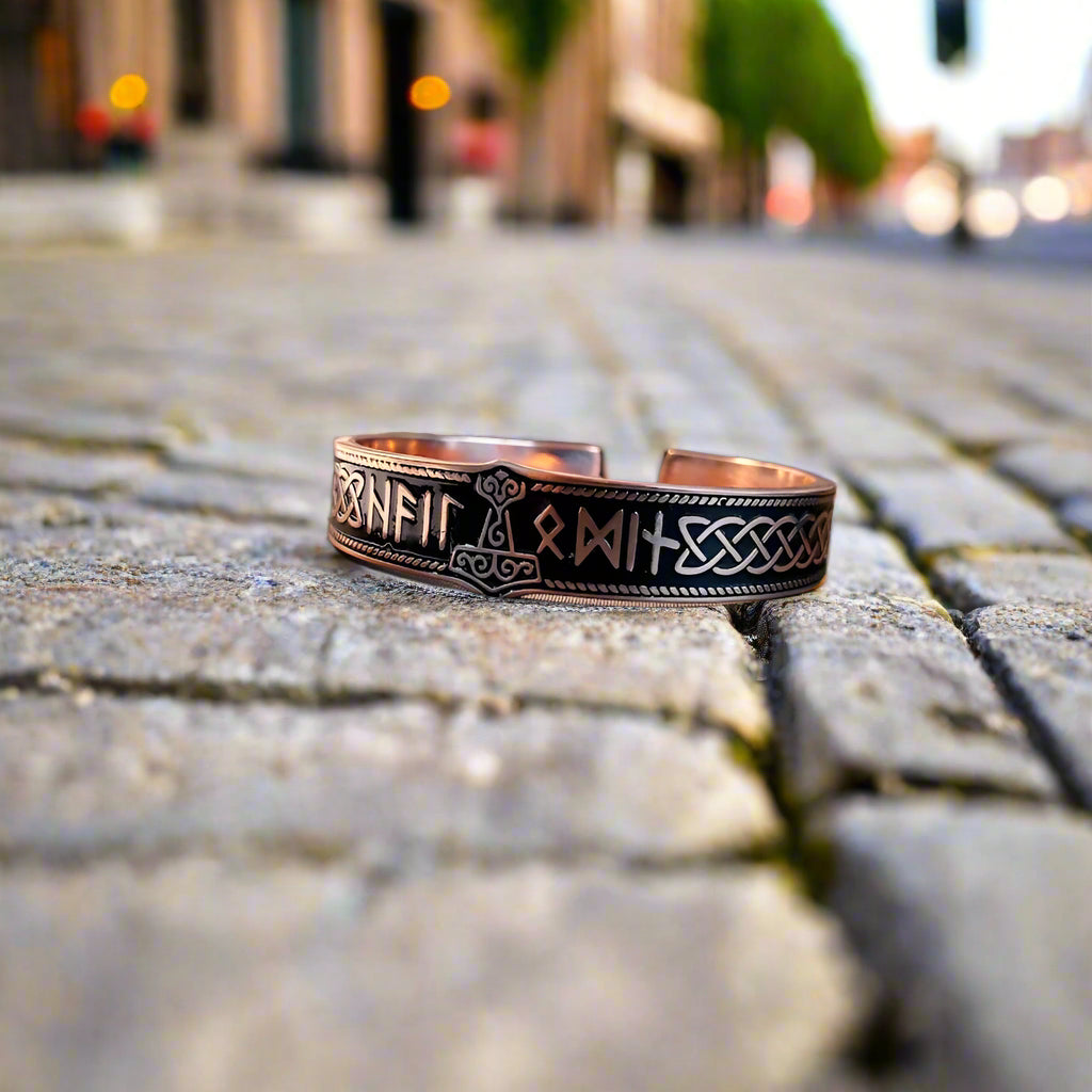 Celtic knot and rune bracelet on a desk with a blurred office background