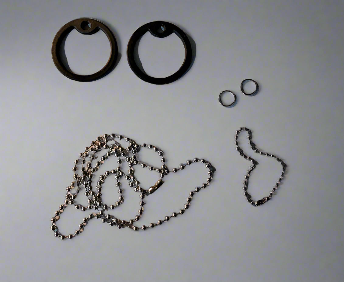 Metal chain and black rubber gaskets on a wooden surface