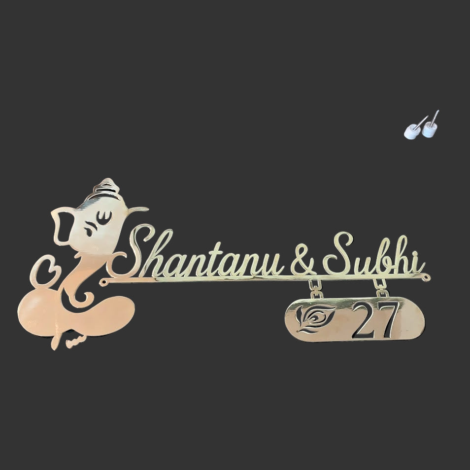 Decorative nameplate with 'Shantanu & Subhi' and number '27' on a desk.