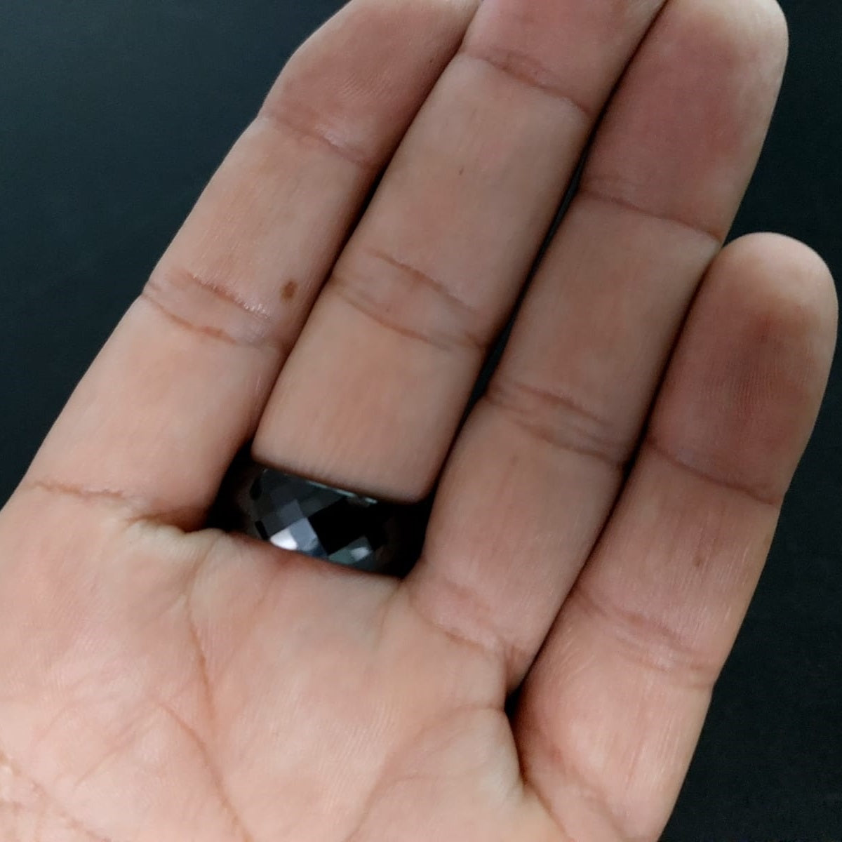 Classic Wide black ceramic ring held in hand for scale