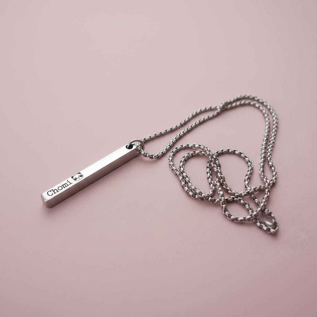 Stainless steel personalised bar pendant necklace on pastel dusty rose background, soft minimal product photography